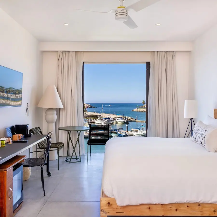Guest room with Juliet doors open to the marina and sea